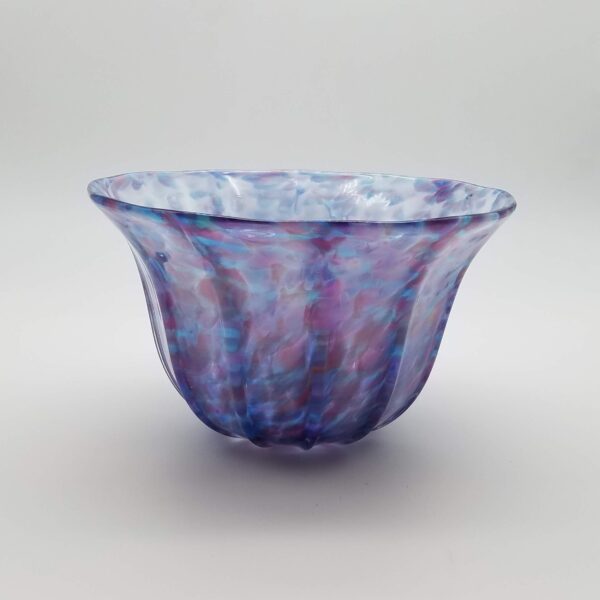 A bowl that is made of glass and has purple swirls.