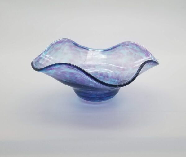 A blue glass bowl sitting on top of a table.