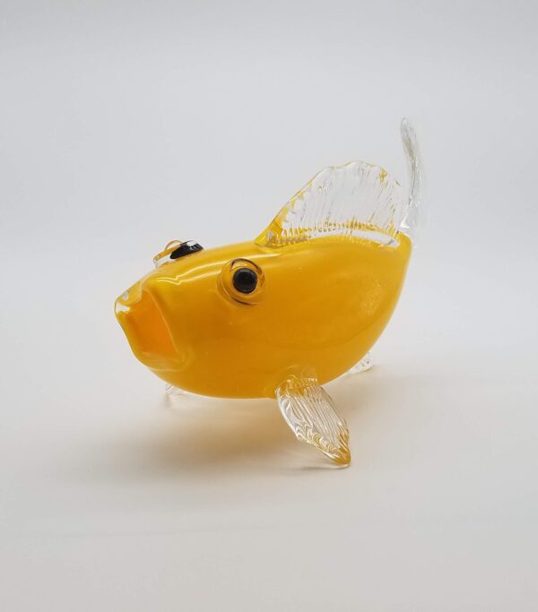 A glass fish is sitting on the table.