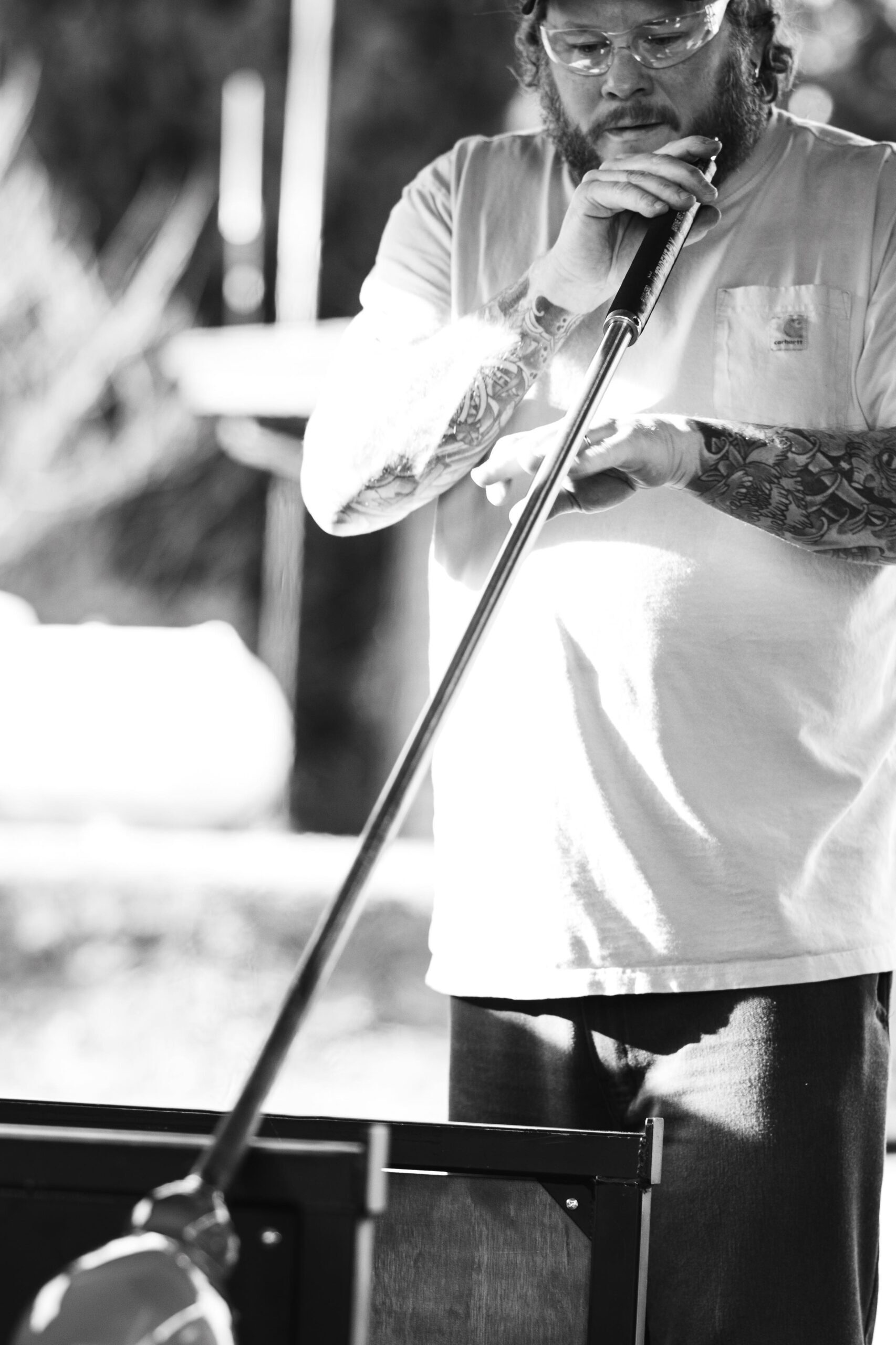A man holding a pole with tattoos on it.