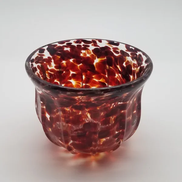 A glass bowl with red and white speckles.