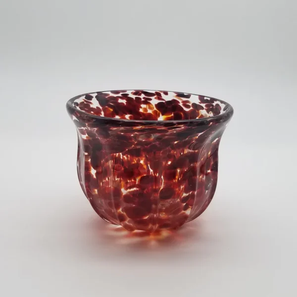 A glass bowl with red and white speckles.