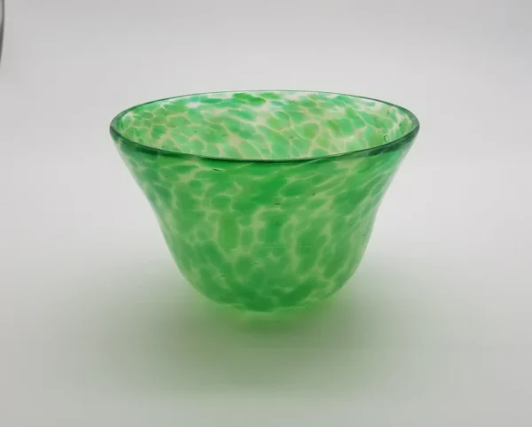 A green bowl sitting on top of a table.