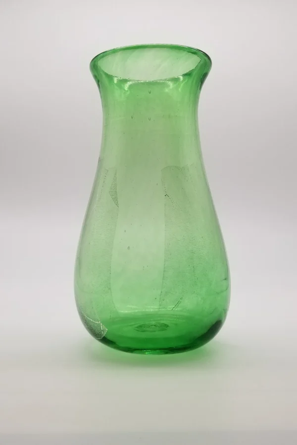 A green glass vase sitting on top of a table.