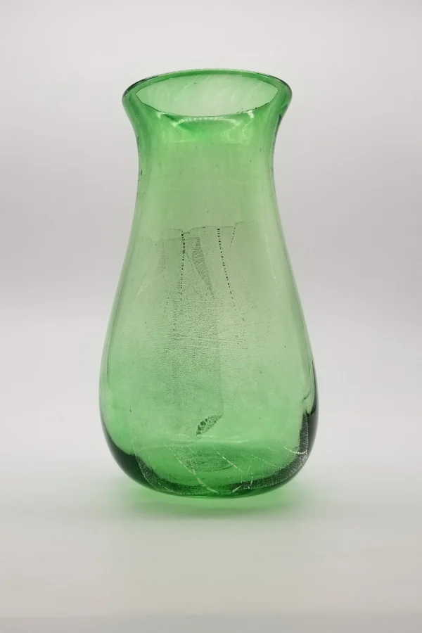 A green glass vase sitting on top of a table.