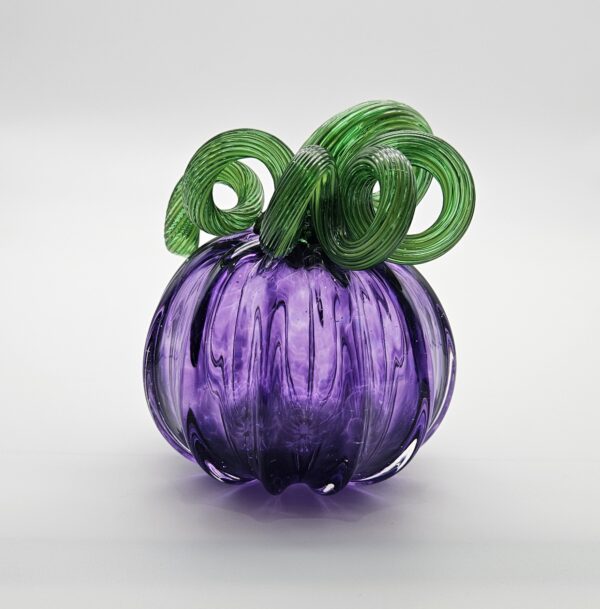 A purple glass pumpkin with green stems.