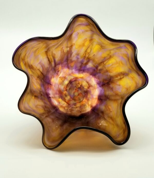 A glass sculpture of a flower with purple and yellow colors.